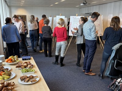 Die Teilnehmenden vor den Tafeln mit Snacks im Vordergrund.